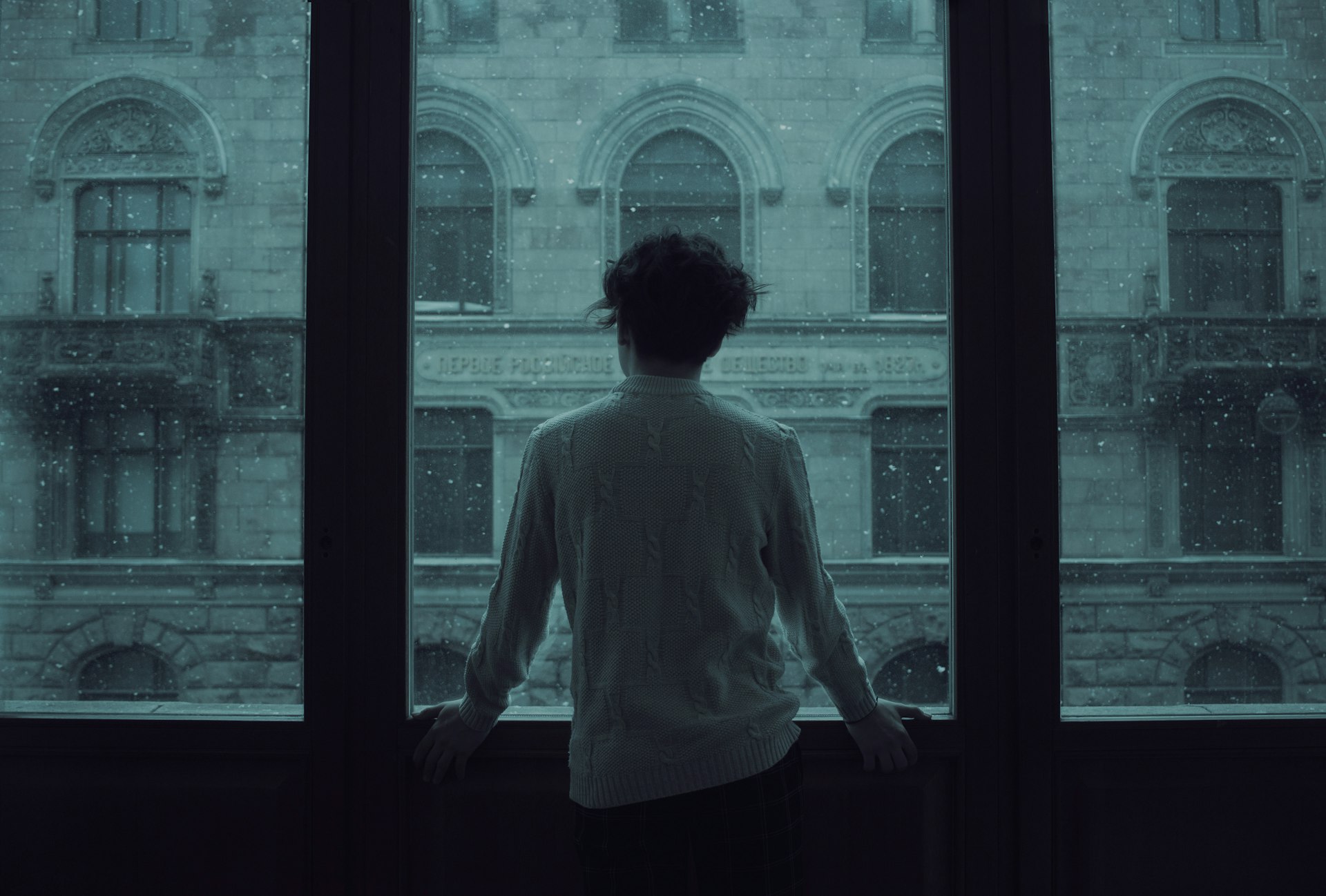 Hombre de espaldas mirando por una ventana