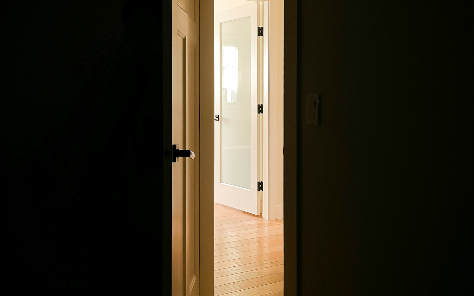 Puerta que se abre hacia una habitación iluminada